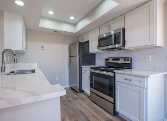 Perimeter Lakes apartments kitchen with white cabinets and stainless appliances