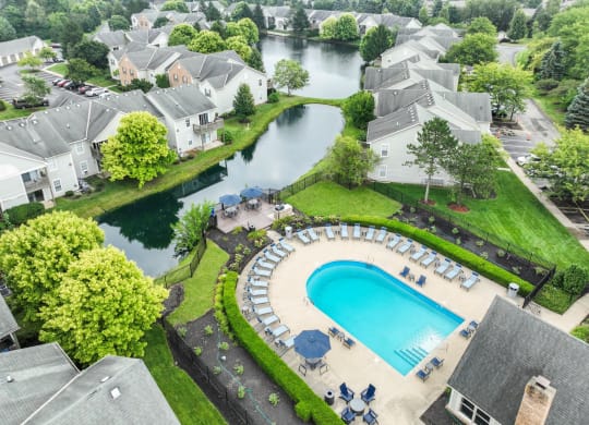 an aerial view of a resort style swimming pool with chaise lounge chairs and umbrellas