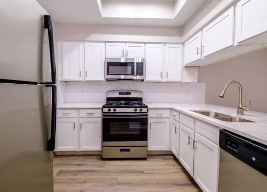 a kitchen with white cabinets and stainless steel appliances