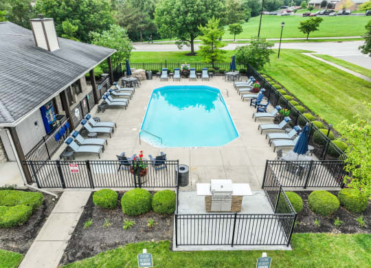 an aerial view of a resort style swimming pool with lounge chairs and umbrellas