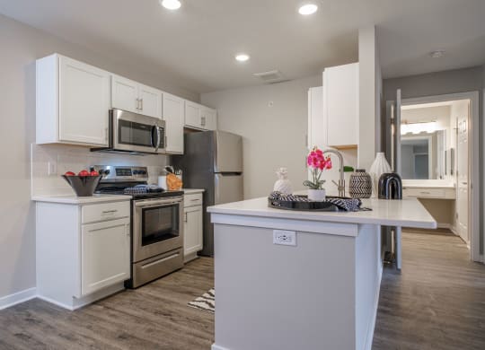 a kitchen with white cabinets and stainless steel appliances at Saw Mill Village apartments