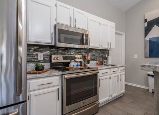 Sterling Park apartments kitchen with white cabinets and stainless appliances