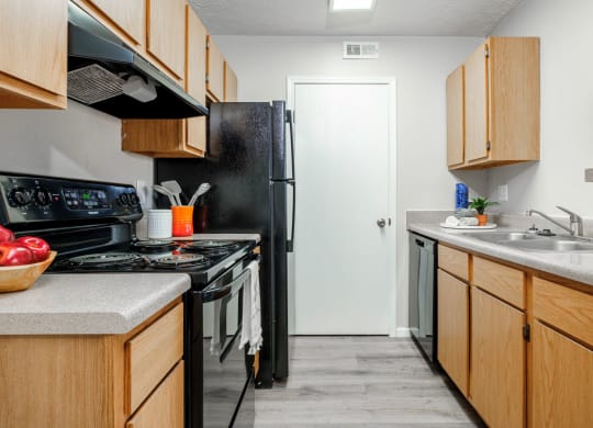 a kitchen with wooden cabinets and a black stove and refrigerator