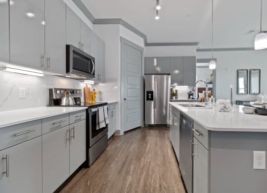 Kitchen gallery with white cabinets  at Reveal Skyline  at La Cantera, Texas