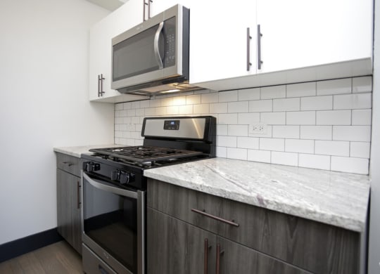 The Edison apartments modern kitchen with stainless appliances and white cabinetry