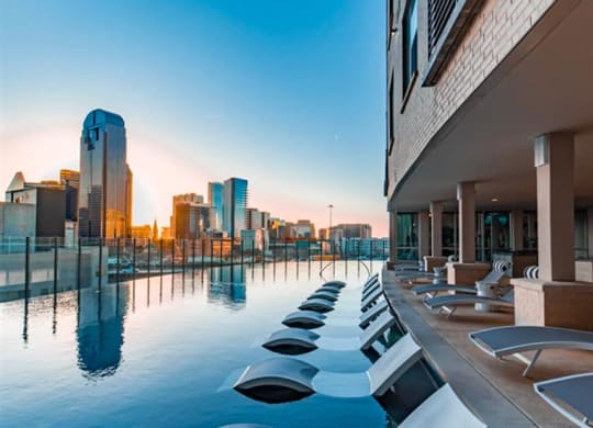 an infinity pool with a Dallas skyline view at The Gabriella apartments