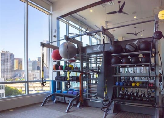 fitness center with a skyline view of Dallas at The Gabriella apartments