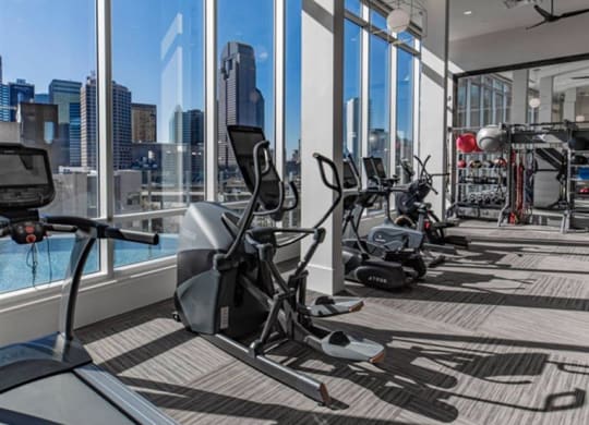 the fitness center with a city view of Dallas at The Gabriella apartments