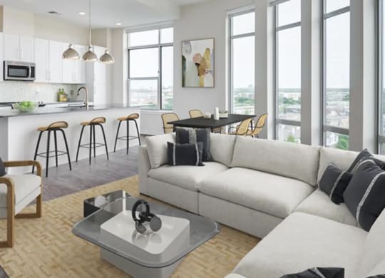 a living room and kitchen with expansive windows at The Gabriella apartments