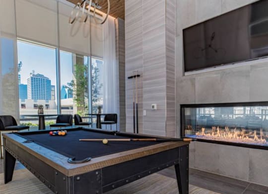 social lounge with billiards and a fireplace at The Gabriella apartments