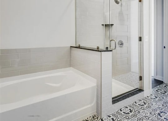a luxury bathroom with soaking tub and glass surround shower at The Gabriella apartments