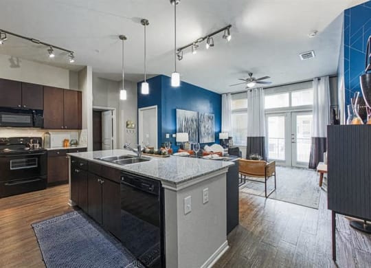 Kitchen with kitchen island and granite countertops and open-concept living area at Aspire at 610 apartments