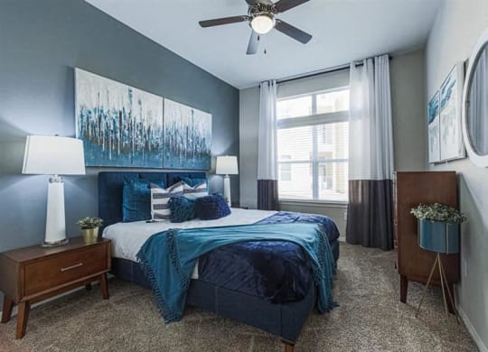 bedroom with ceiling fan and expansive windows at Aspire at 610 apartments