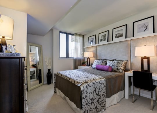 a bedroom with a bed and a desk with a chair at The Millennium, Virginia, 22202