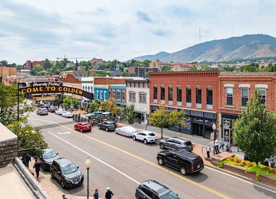 A street view of a town with cars and buildings.