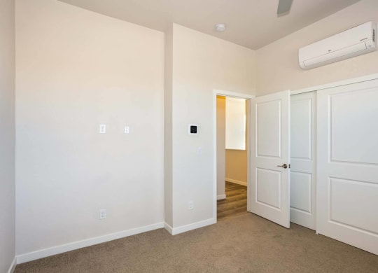 Interior view of open floor plan bedroom with door at Brownstones at Palisade Park, Broomfield, 80023