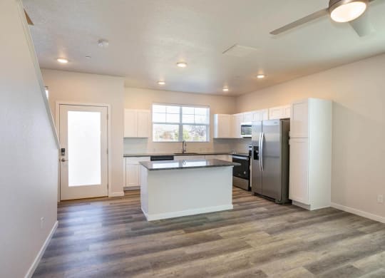 open floor plan living room with granite kitchen island at Brownstones at Palisade Park, Broomfield