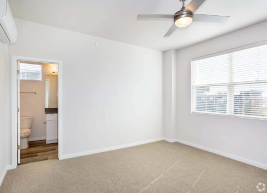 Bedroom with attached bath and windows with open floorplan at Brownstones at Palisade Park,  Colorado
