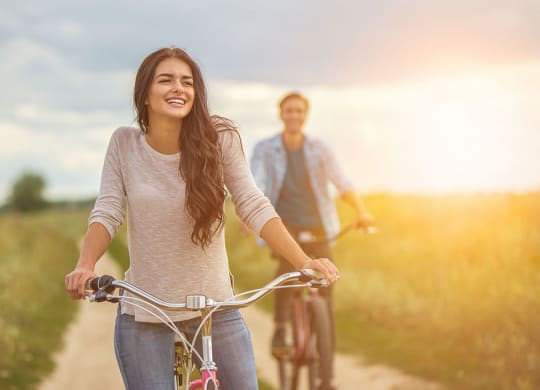 a woman riding a bike with a man at Brownstones at Palisade Park, Broomfield, 80023