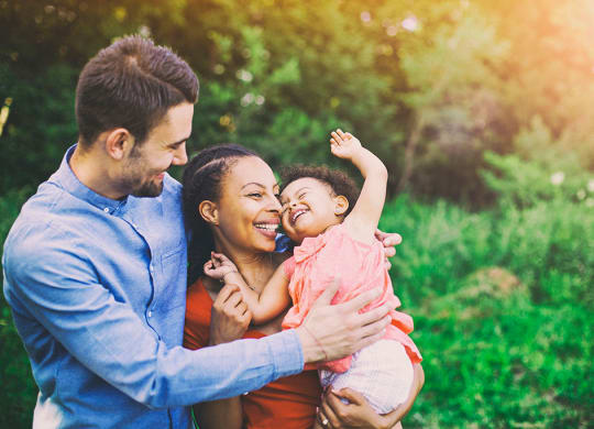 a man and woman holding a baby at Brownstones at Palisade Park,  Colorado, 80023