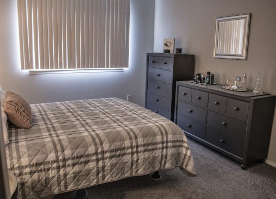 a bedroom with a bed and dresser and a window