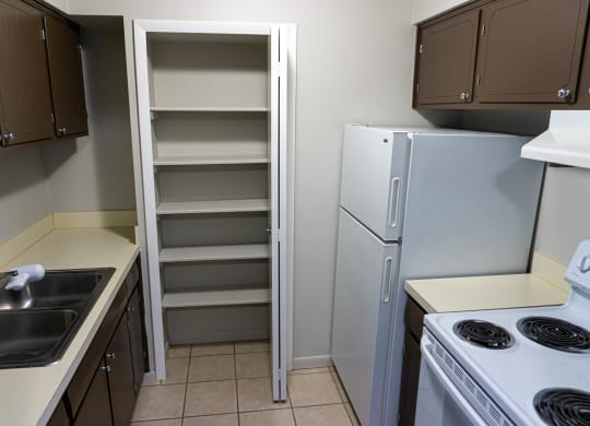 Fully equipped kitchen with ample closet space at Carriage House Apartments in Flint, Michigan