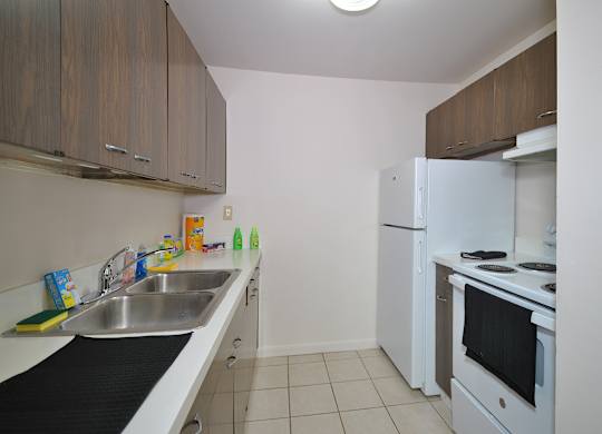 A kitchen with white appliances and brown cabinets.