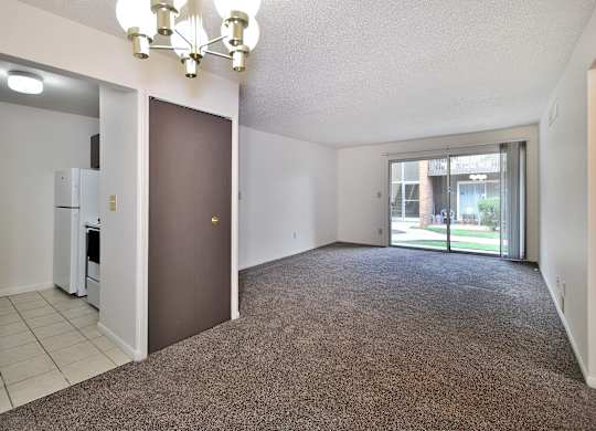 A room with a brown carpet and a chandelier.