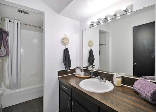 Modern bathroom at Woodcrest Apartments in Westland, MI featuring updated fixtures, a spacious vanity, and bright lighting.