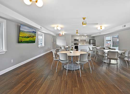 Resident clubhouse with comfortable seating, community tables, and bright natural light at Warren Woods Apartments in Warren, MI.