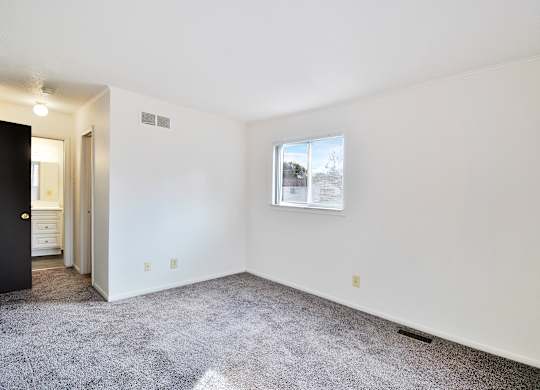 A room with a carpeted floor and a picture on the wall.