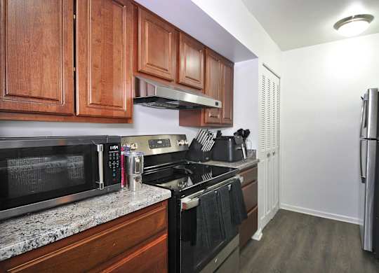 A kitchen with wooden cabinets and black appliances.