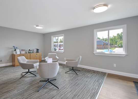 Leasing office lounge with contemporary seating area and welcoming reception at Warren Woods Apartments in Warren, MI.