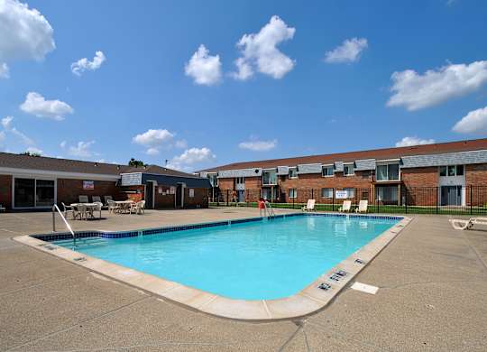 A large swimming pool in front of an apartment building at Warren Woods in Warren, MI