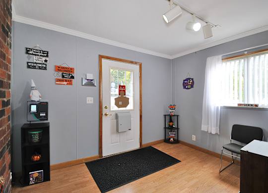 A room with a brick wall and a door with a sign on it.