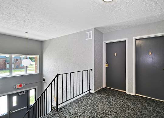 A hallway with two doors and a staircase.