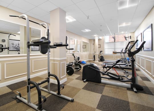 a gym with weights and exercise equipment in the lobby of a building