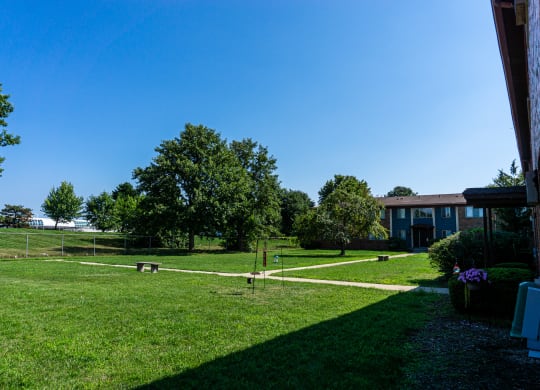 Large courtyard with sidewalks and benches at Golf Manor Apartments in Roseville, Michigan