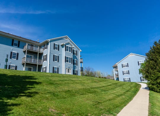 Sidewalk and apartment building on hill with view. Apartments for rent in Kalamazoo, MI near WMU Western Michigan University
