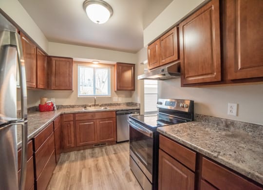 Newly renovated kitchen with granite countertops and stainless steel appliances at Westwind Tonwhomes in Lansing, Michigan