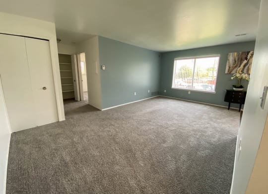 Spacious living room with window and hallway to other rooms, at Gale Gardens Apartments