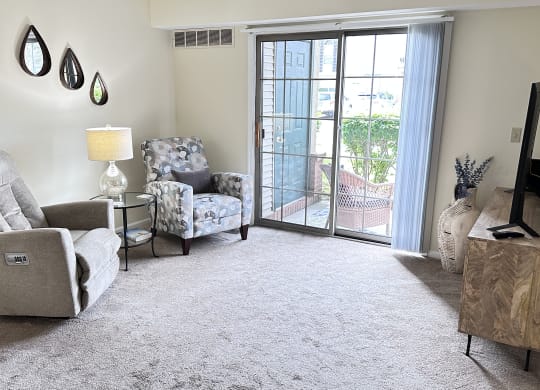 a living room with two chairs and a sliding glass door