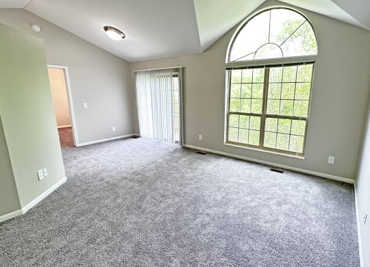 an empty living room with a large window