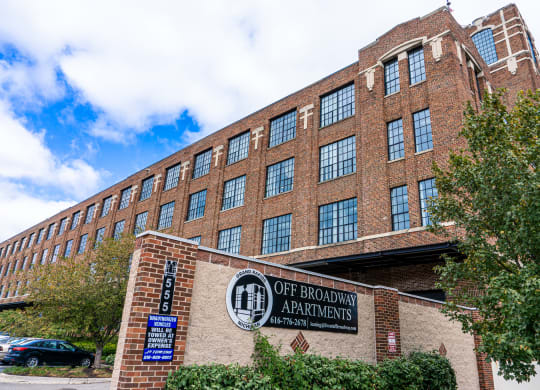a large brick building with a sign that reads off broadway apartments