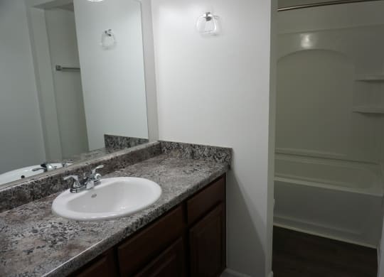 Bathroom with granite countertops at Woodcrest Apartments in Westland, Michigan
