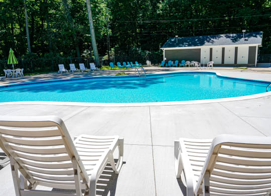 Swimming pool and pool chairs at Woodcrest Apartments in Westland, Michigan