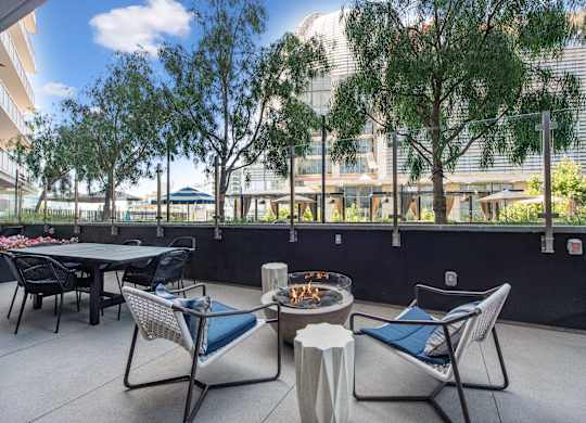 Outdoor patio with tables and chairs and a fire pit at K1 Apartments, San Diego