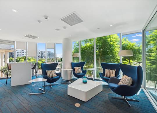 Living room filled with blue chairs at K1 Apartments, San Diego, California