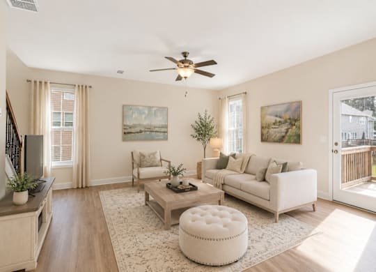 A living room with a white couch, a coffee table, and a ceiling fan.