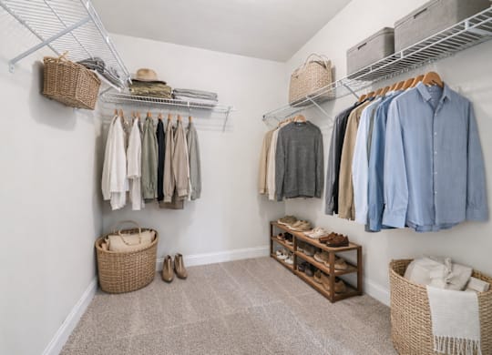 Primary suite with a full walk in closet featuring custom racks.